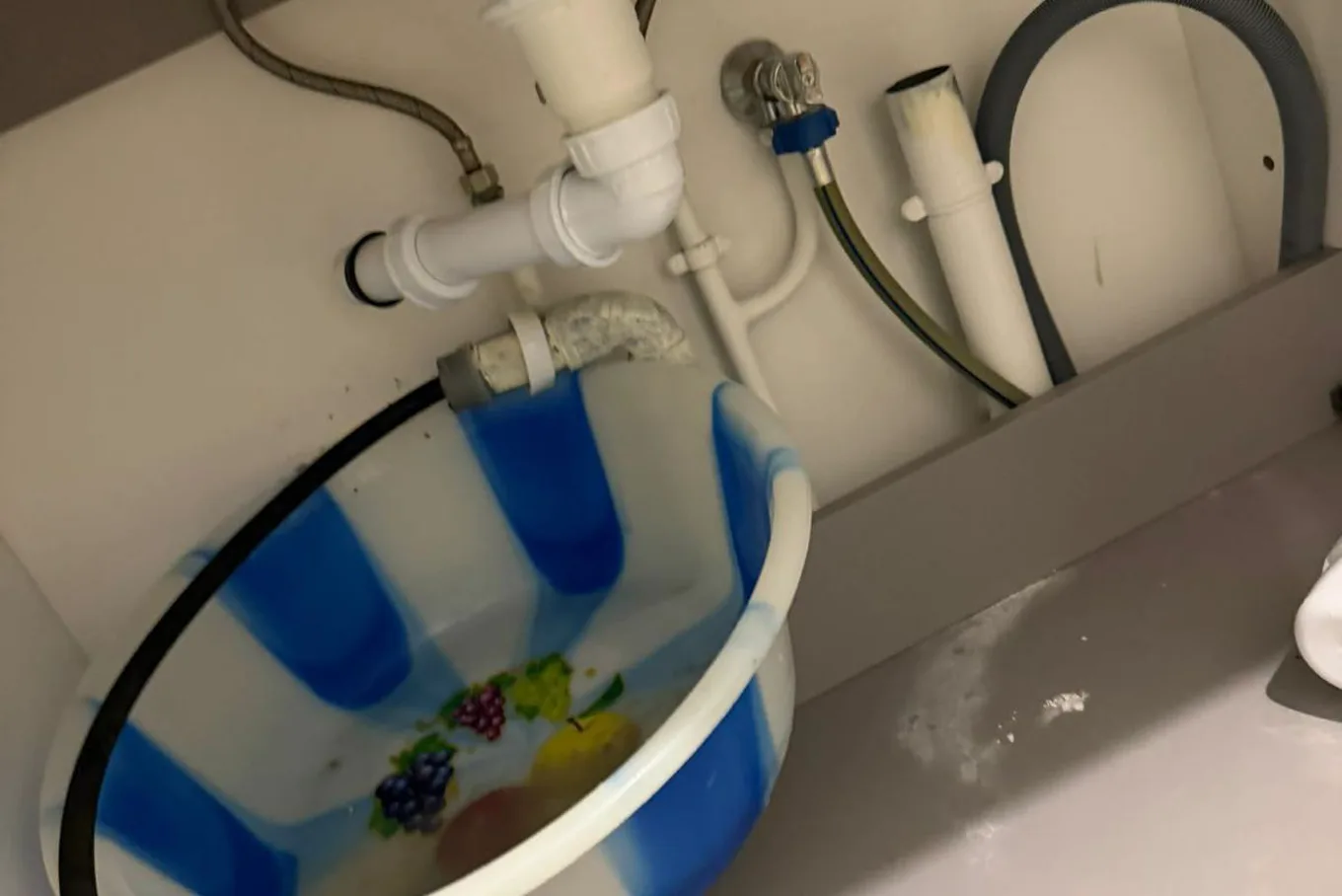 Plombier démontant un siphon d'évier pour déboucher une évacuation à Saint-Denis